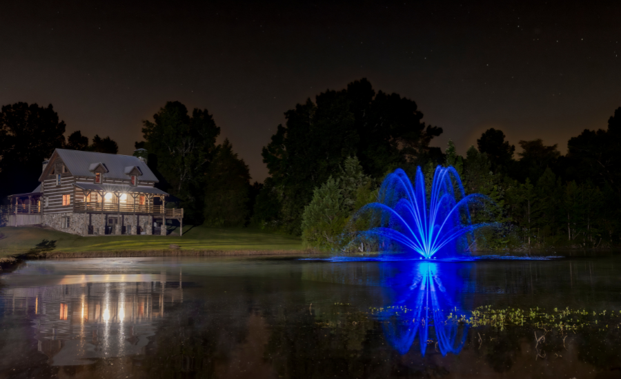 Pond Fountain With Beautiful Blue Lights At Night In A Backyard Pond