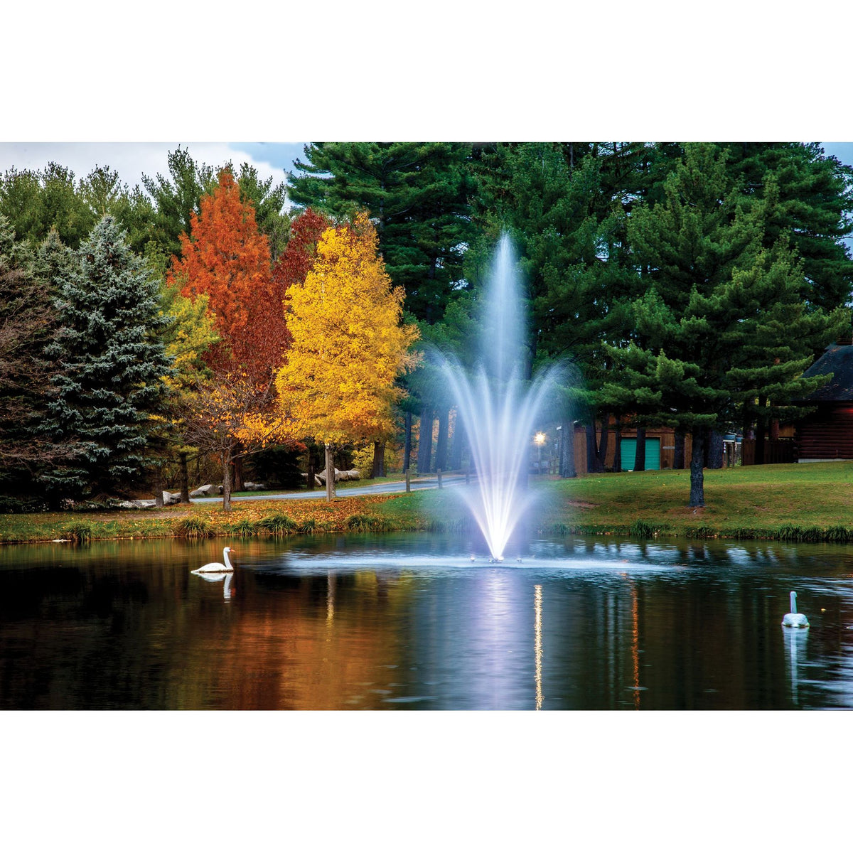 Scott Aerator Amherst Pond Fountain With White Glowing Lights In A Small Pond During Fall