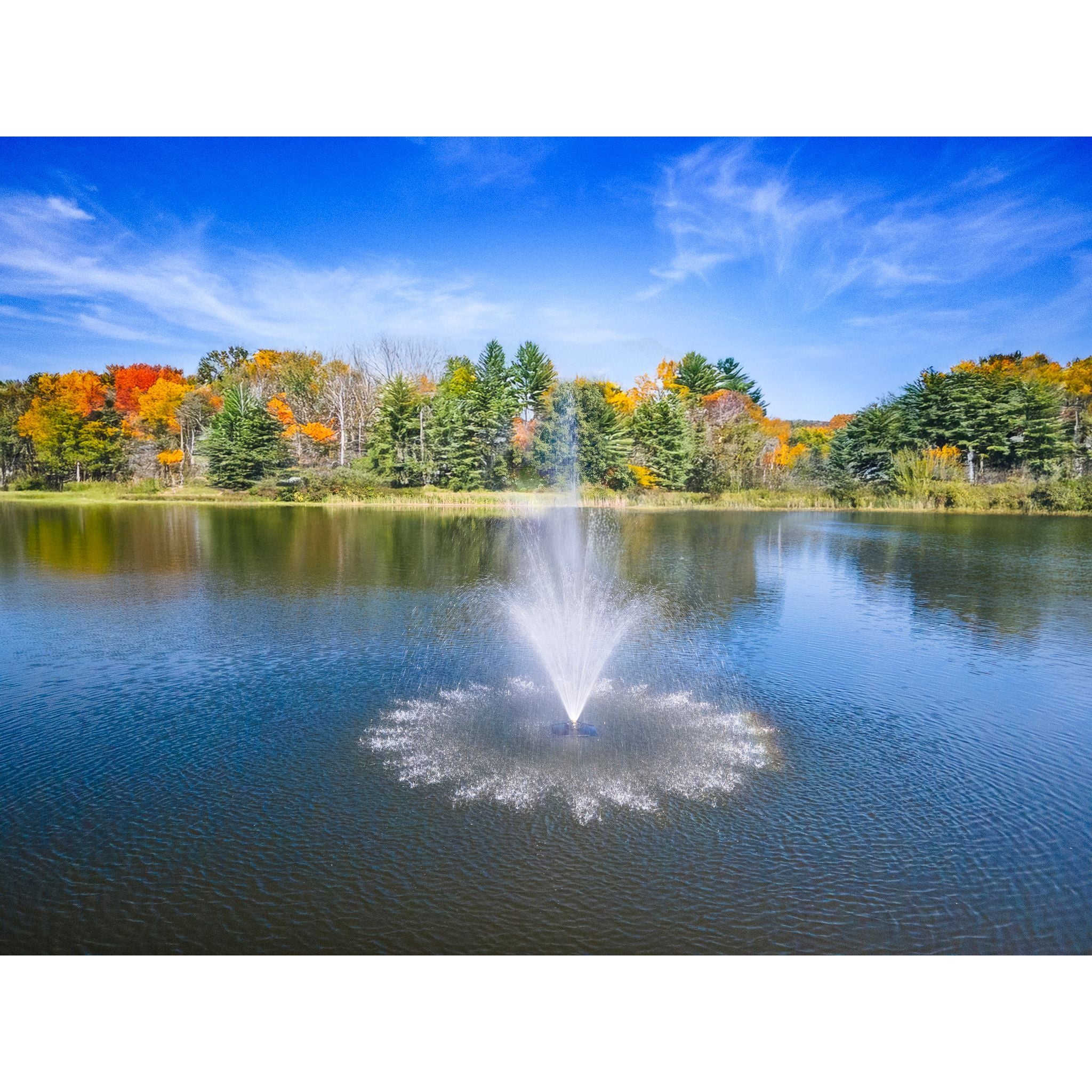 Amherst Pond Fountain In A Large Lake During The Daytime With Trees In The Background